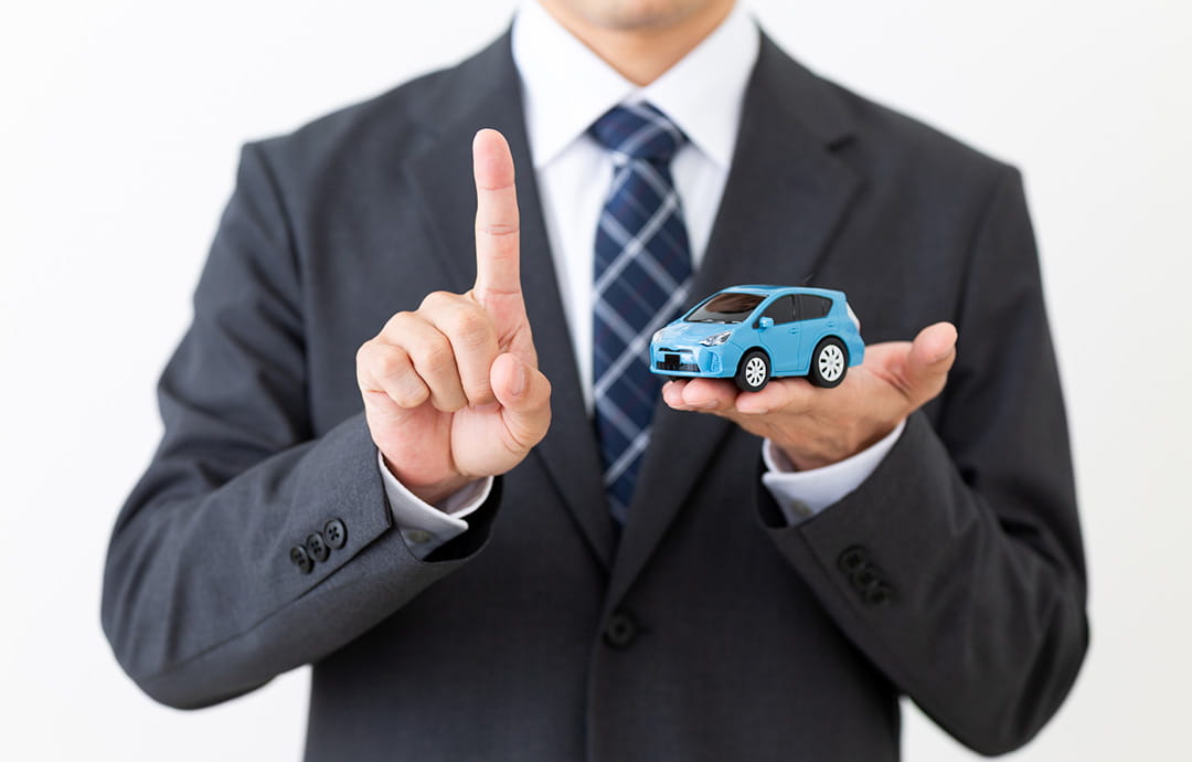 車の模型を持ったスーツの男性
